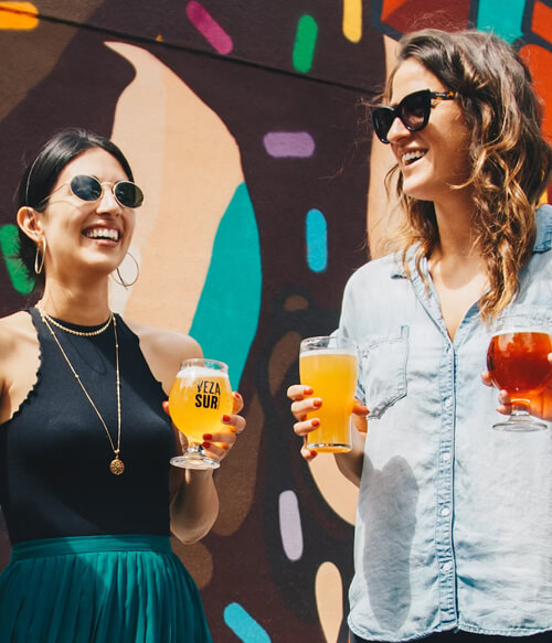 two people holding beers